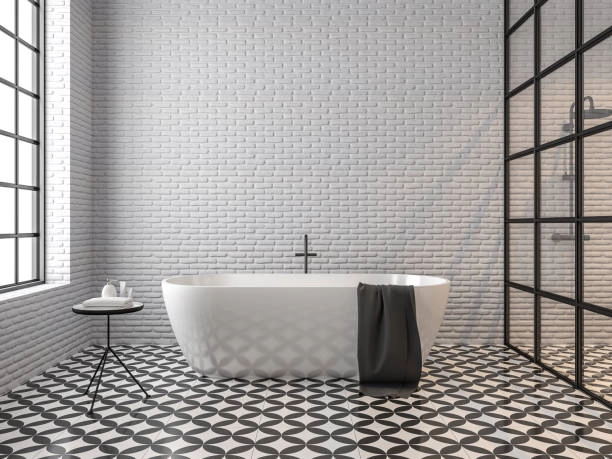 bathroom with black and white floor tile, white bath rub with grey towel, small table -bathroom tile