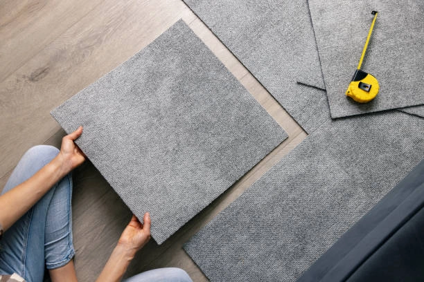 person installing grey carpet tiles -carpet tiles