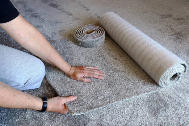 person unrolling grey carpet tiles -carpet tiles