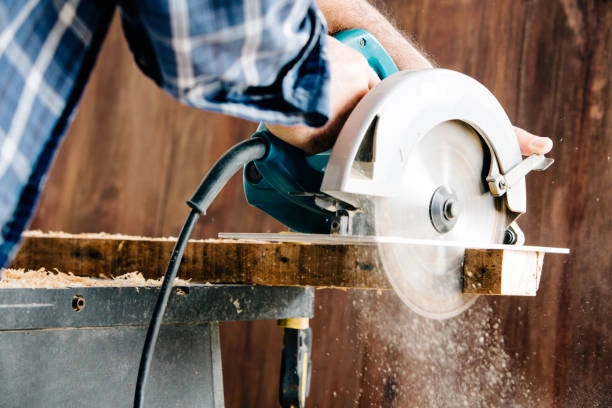 Person cutting wood with a circular saw, sawdust flying. -carpentry services