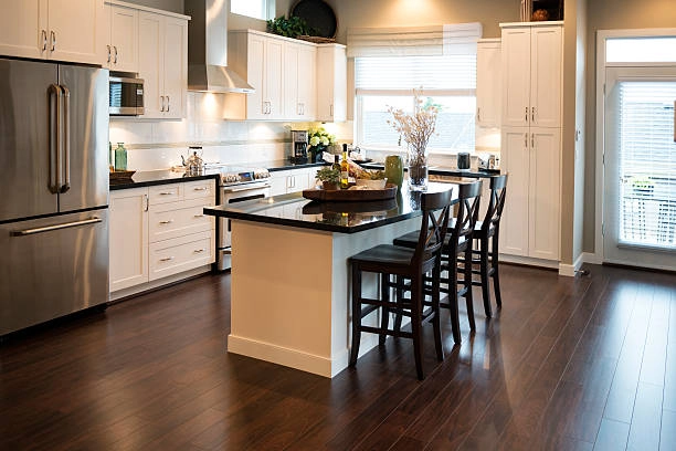 Warm, inviting kitchen with white cabinets, dark wood flooring, island. -kitchen remodel contractor