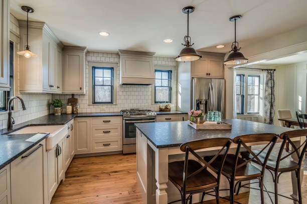 Cozy farmhouse-style kitchen with wood floors, island, and pendant lighting. -contractor for kitchen remodel