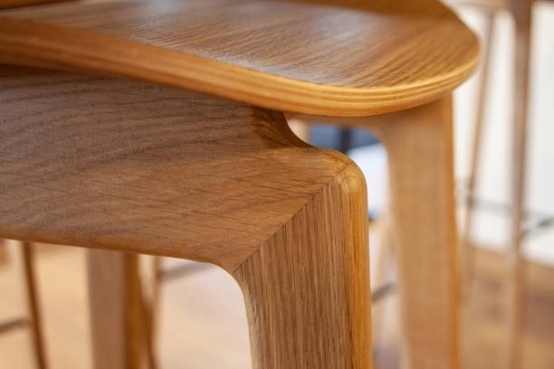 Close-up of wooden chair's curved joinery, showcasing craftsmanship details. -trim carpentry